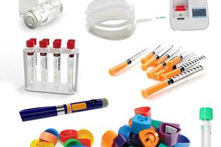 collection of plastic medical packaging and products, including vaccine vials, breathing mask, electronic sensor, COVID-19 test vials, needle casings, and caps