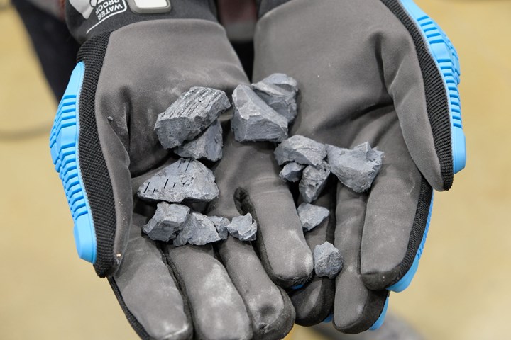 Gloved hands holding shredded material.
