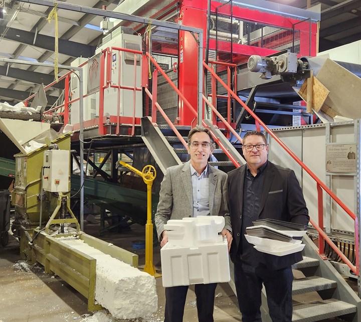 Two men with polystyrene packaging products stand in front of equipment. 