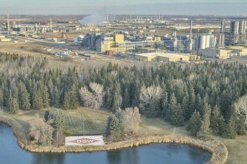 Aerial image of Dow Canada existing plant with lake and group of evergreen trees in foreground.