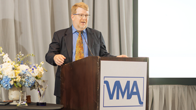 Image of Andy Duff, new BOD chair for VMA in front of podium at annual meeting.