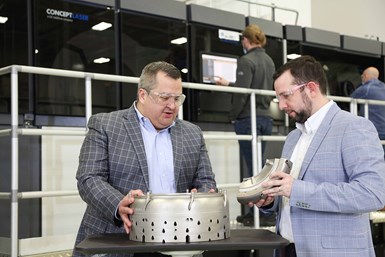 Benito Trevino, general manager – additive integrated product team, GE Aviation, and Chris Philp, ATC site leader, GE Aviation, stand in front of the GE Additive M Line system installed at GE Aviation’s Additive Technology Center  in West Chester, Ohio. Photo Credit: GE Additive