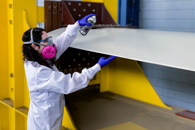 A person spraying a coating on a wing.