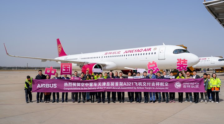 A321neo aircraft on the tarmac with Juneyao Air employees in front.