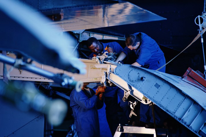 Flight engineers repairing an aircraft wing.
