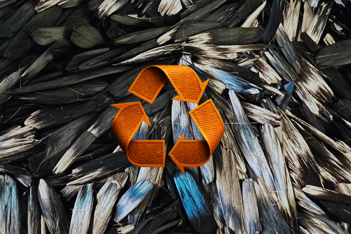 Carbon fiber scrap with an orange recycling logo.