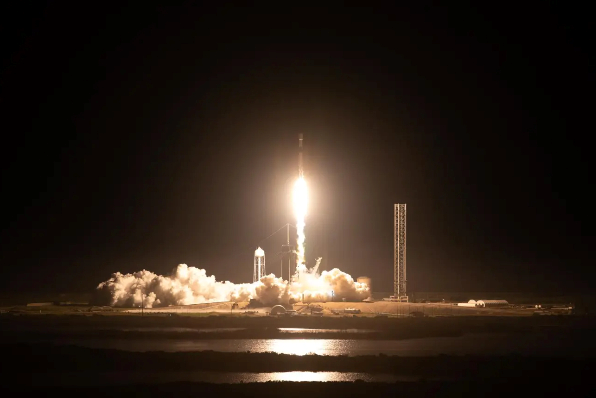 A SpaceX Falcon 9 rocket carrying Intuitive Machines’ Nova-C lunar lander lifts off in the distance.