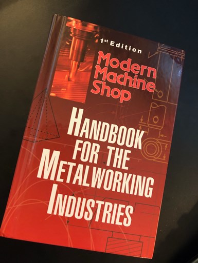 A photo of Modern Machine Shop's Handbook for the Metalworking Industries on top of a desk.