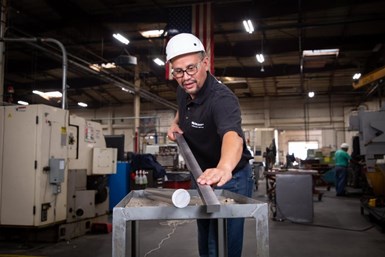 A picture of a TCI Precision Metals employee preparing a square machine-ready blank