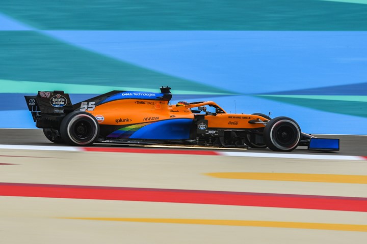 An orange McLaren racing car on a track.