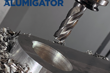A photo of the Alumigator ASR-5 end mill above a workpiece, with chips surrounding the workpiece