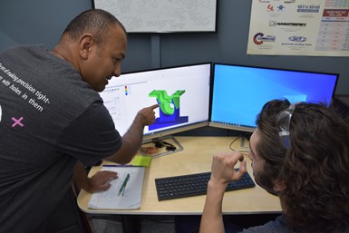 A photo of production manager Tirath Singh working with a machinist to program a part in CAMWorks