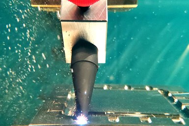 An image of an EDM head machining while submerged in water