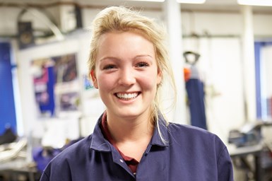 woman in manufacturing setting smiling