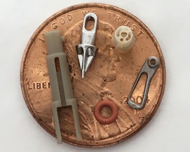A photo of five micromachined parts on the face of a penny.