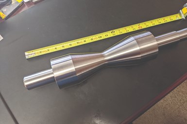 A photo of a v-roller part with a ruler alongside it