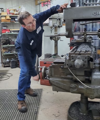 Josh Topper manipulates the handwheels of his manual horizontal machining center at his home machine shop in rural Wisconsin.