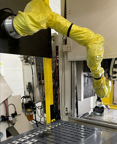 A photo of Wagner Machine's first cobot, which is wearing a poncho to waterproof it. The cobot is side-mounted in its frame.