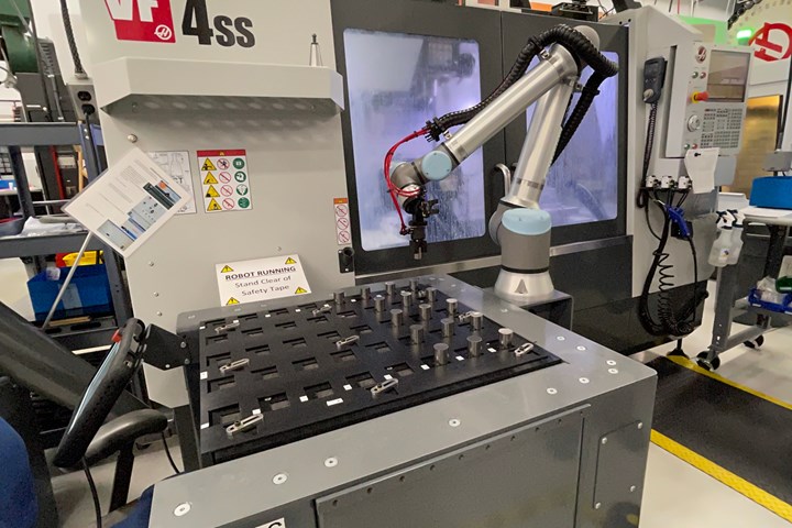 A robot loads parts into a vertical machining center on the shop floor at Metal Craft, a manufacturer of surgical tools. 