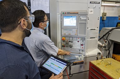 A photo of Leesta employees using JITbase while inspecting a program on a machine
