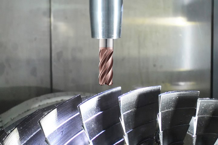 A solid carbide cutting tool hovers above the blades of a metal disc.
