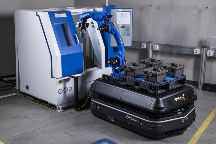 Una foto de un robot montado en un AMV cargando una máquina desde canastas de piezas también montadas en el AMV.