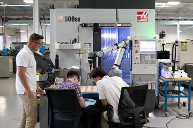 SDP SI Employees working at a Haas attended by a cobot