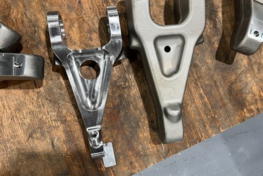 A forging of the torque arm next to a machined version of the part
