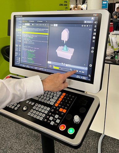 A photo of a man tapping the touchscreen of a Heidenhain TNC 7 control