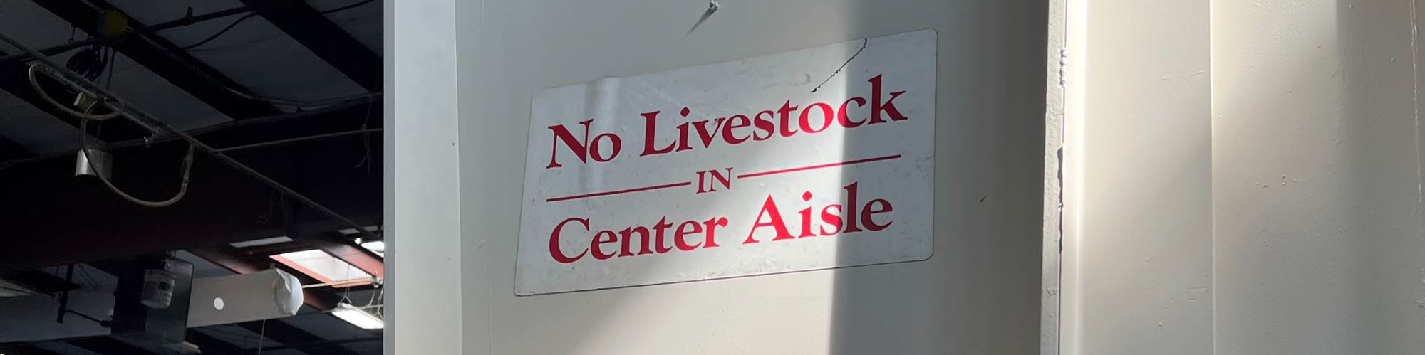 Sign reading "No Livestock in Center Aisle" posted inside an exhibition hall during Eastec 2023