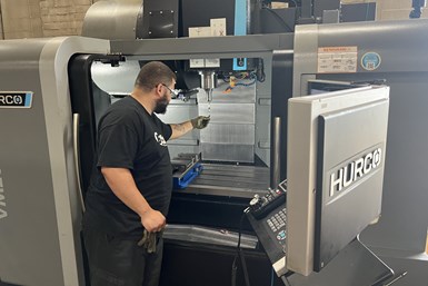 A Barbco employee checking the tooling of a Hurco VM20i