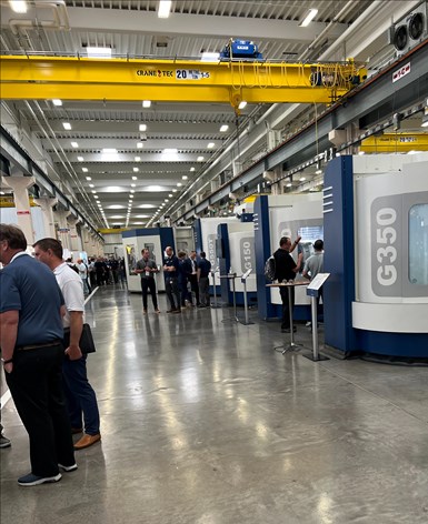 A line of GROB universal machines, with event attendees looking at them.