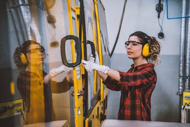 A woman interacting with a machining center.