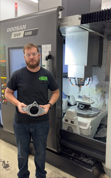 A photo of Tyler Thompson, vice president of TTI Machine, in front of the shop's DN Solutions DVF 5000.