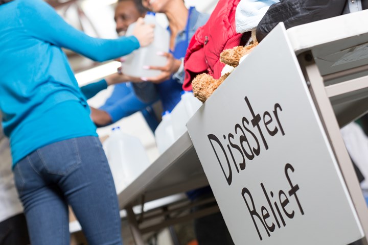 Closeup of Disaster Relief sign at center handing out water.