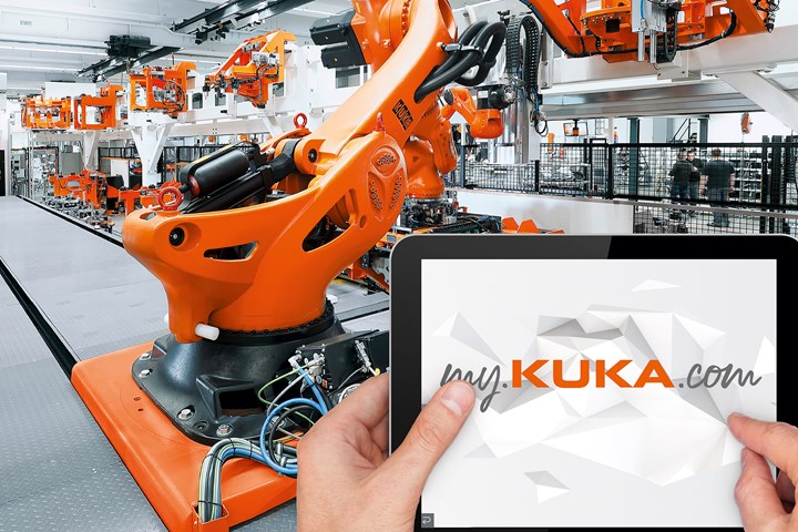 KUKA robots behind a screen showing the KUKA website.