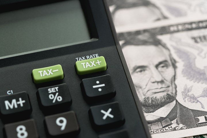 Close-up shot of TAX minus/plus buttons with text TAX RATE on calculator 