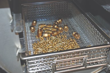 small, clean machined metal parts in a basket