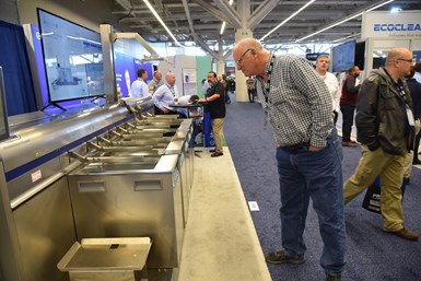 PMTS attendee looks at parts washers on show floor