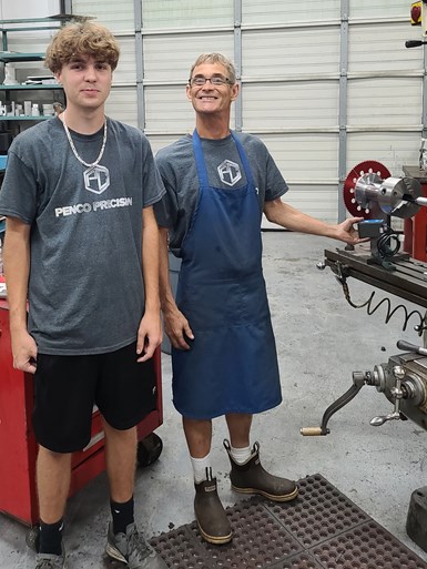 an apprentice with a machinist working at PenCo Precision