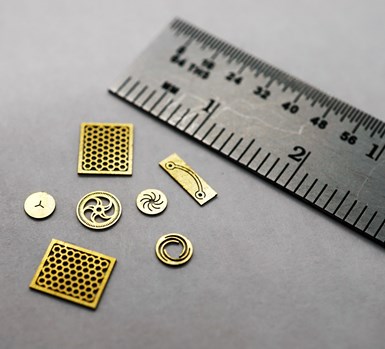 micromachined metal parts next to a ruler