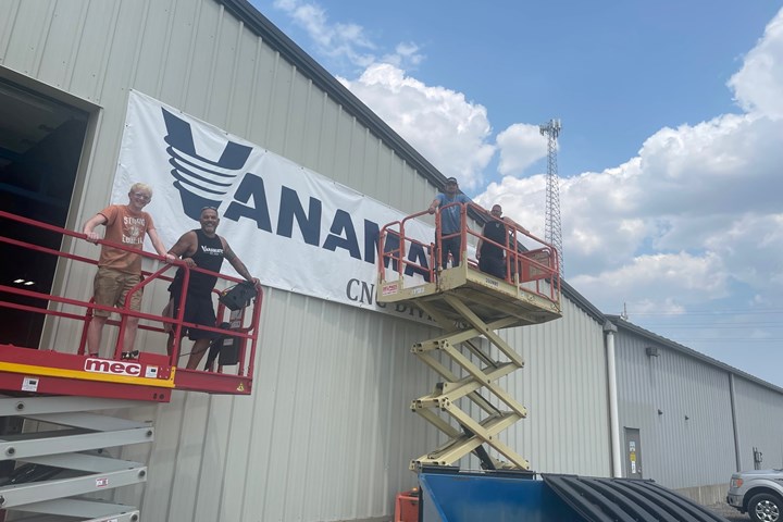 men on lifts putting Vanamatic sign on CNC Division building