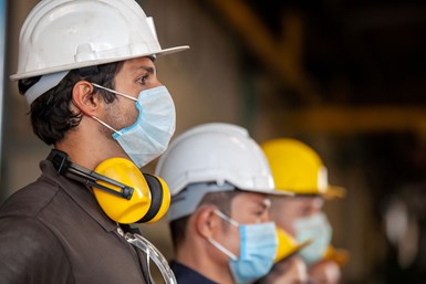 Three workers standing in a line looking to the right. 