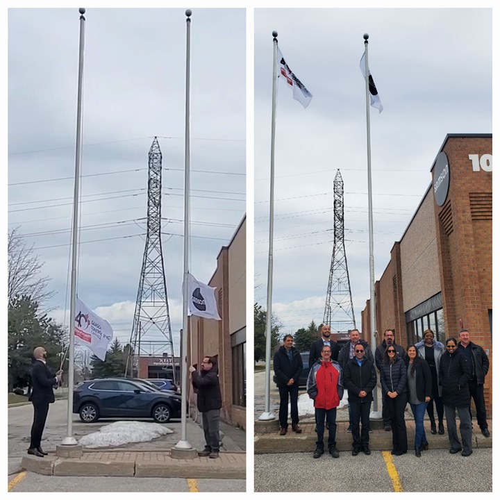 Image of two flags being raised to celebrate 40th anniversary of SAMSON Controls, with employees posing in front of raised flags.