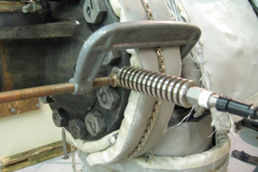 Image of caliper holding sensor onto tubing coming out of valve.
