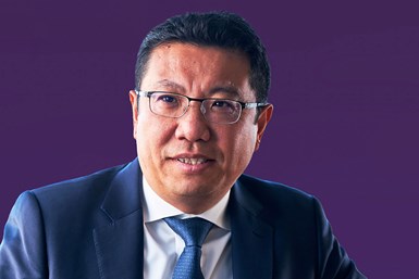 Photo of IMI Automation CEO Jackie Hu wearing dark blue suit, white shirt, blue tie in front of a dark purple background