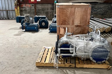 Photo of commercial warehouse with industrial pipe wrapped and stacked on a a pallet with other boxes of equipment.