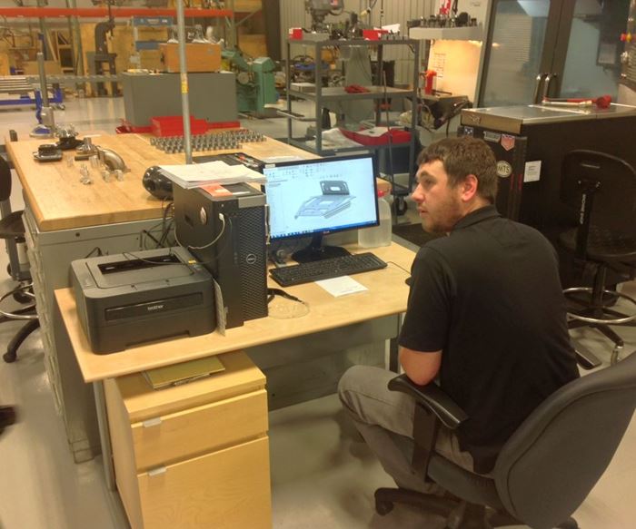 TMI Autotech employee looks over part drawing