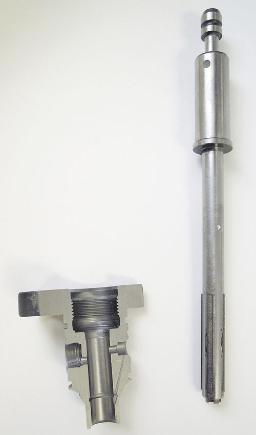 Aquí se muestra una herramienta de bruñido superabrasiva junto a un cuerpo de inyector de combustible de agujero pasante. 